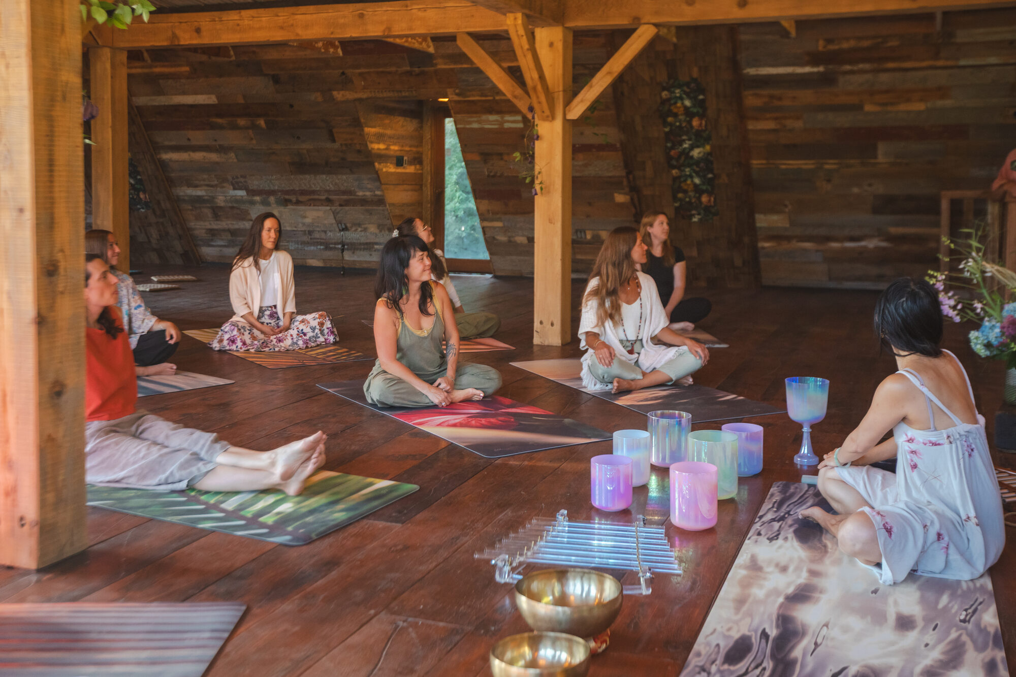Seated circle with singing bowls inside the barn at Akasha Farm